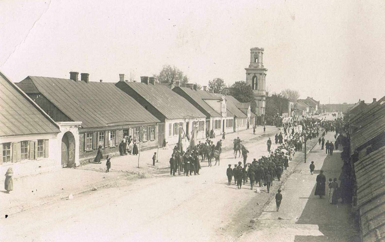 Ulica Długa (obecnie Jana Pawła II) między Dużym Rynkiem a kościołem ewangelickim. Fotografia przedstawia prawdopodobnie pochód niemieckiego towarzystwa strzeleckiego (między 1915 a 1921)